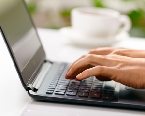 Woman hands typing on laptop
